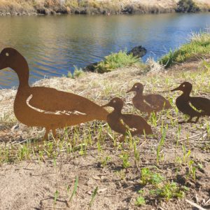 Laser-cut Standing Duck Family Garden Stake featuring a duck and ducklings in weather-resistant Corten steel, with easy-to-install ground spikes.