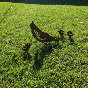 Pecking Hen Family Garden Stakes featuring one pecking hen and three chicks, crafted from rusted Corten steel, ideal for garden beds and large pots.