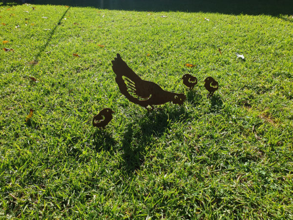Pecking Hen Family Garden Stakes featuring one pecking hen and three chicks, crafted from rusted Corten steel, ideal for garden beds and large pots.
